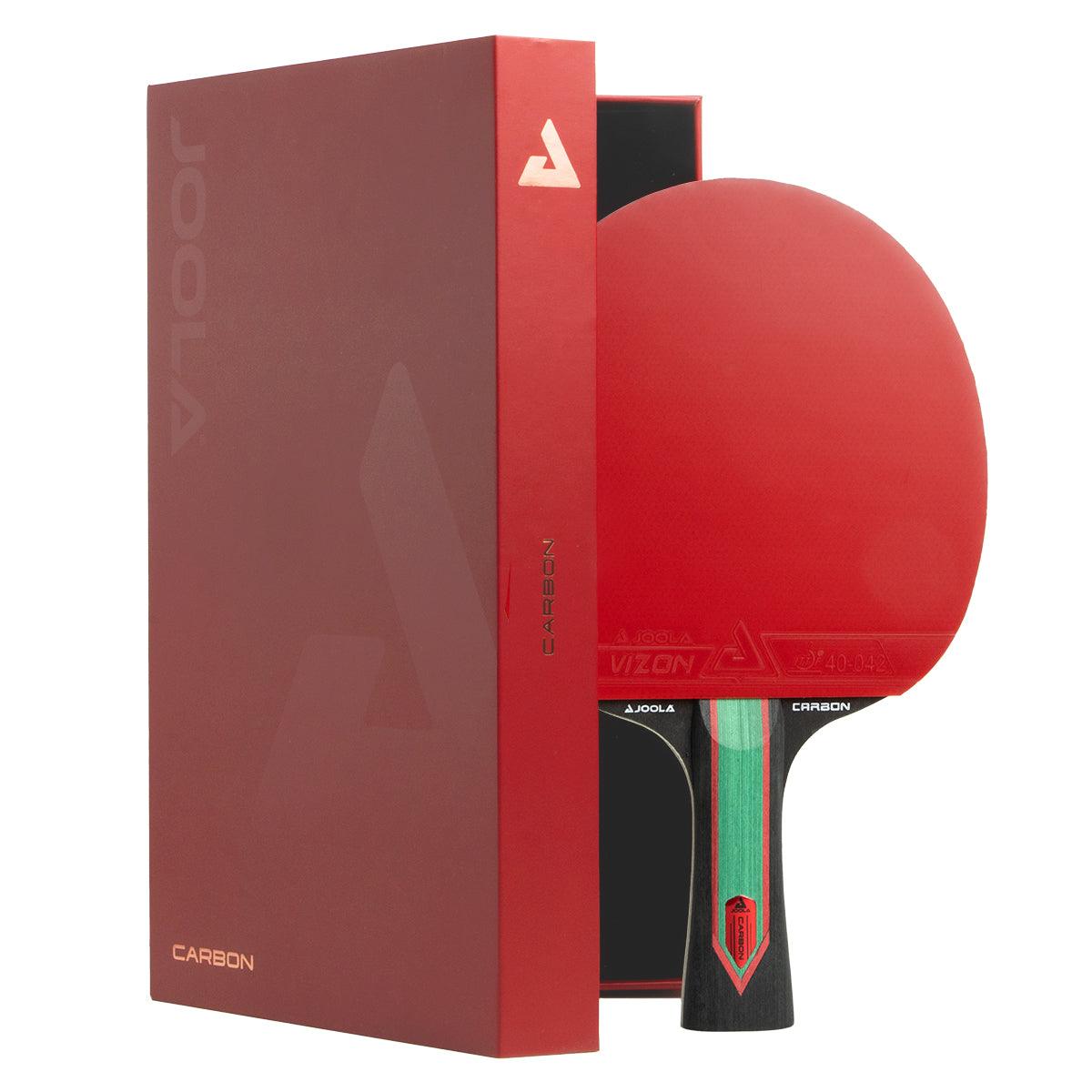 Tischtennisschläger mit rotem Belag und schwarzem Griff neben roter Verpackung mit Aufschrift "Carbon".