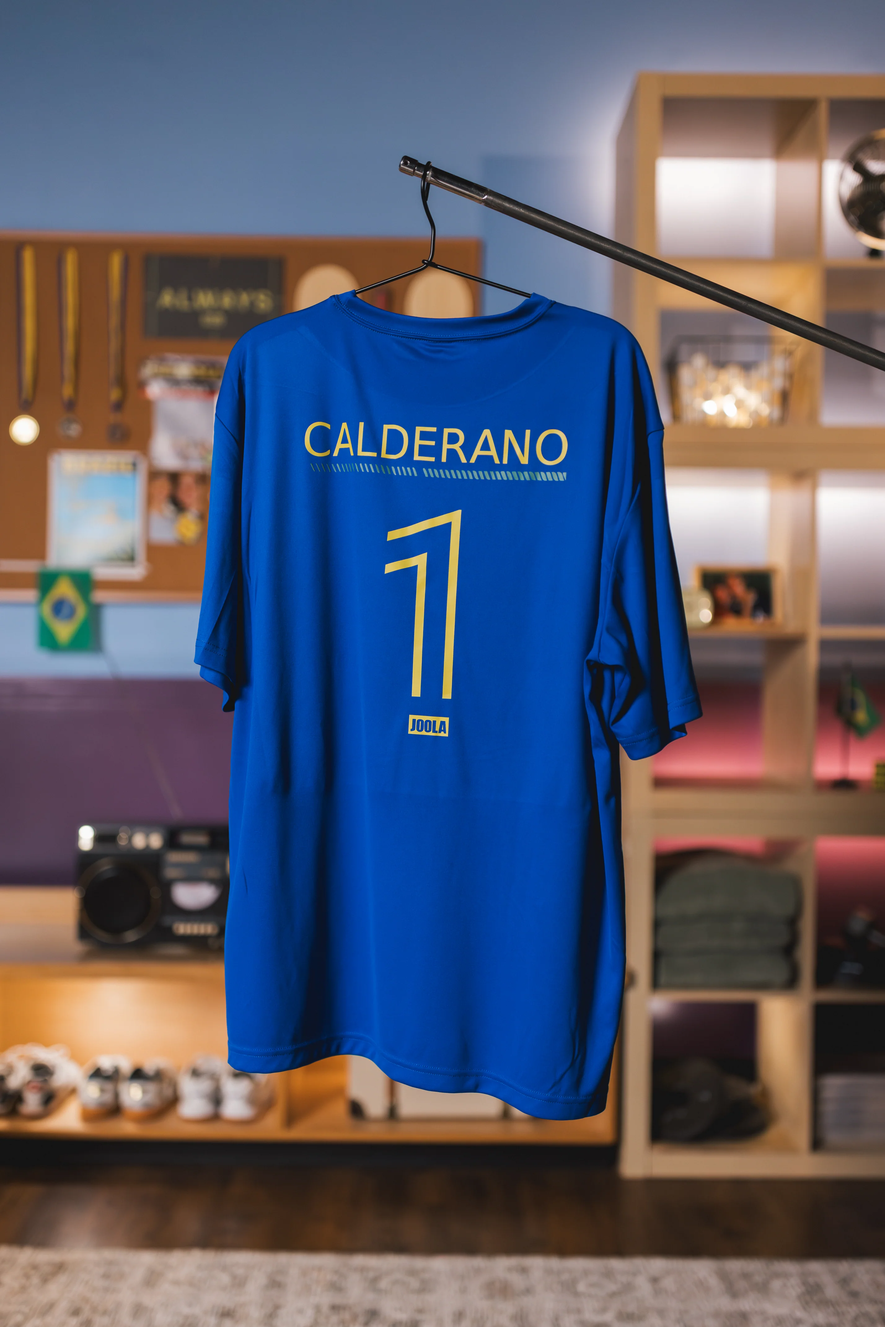 Blaues JOOLA Trikot von Hugo Calderano hängt an einem Kleiderbügel